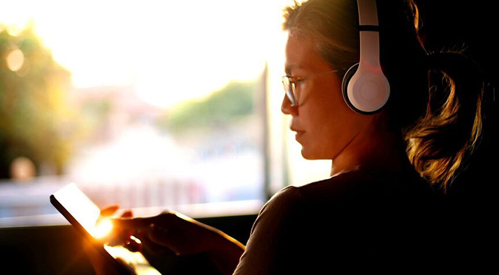 Woman wearing headphones using tablet