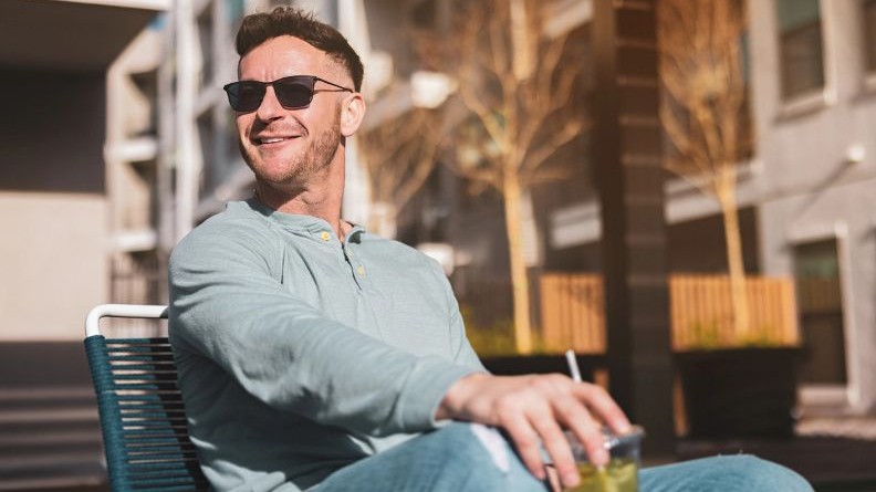 Woman wearing photochromic lenses outdoors while using mobile device